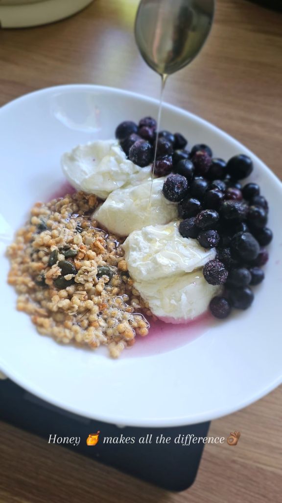 Breakfast featuring granola, yoghurt and berries with honey for low-calorie sweetness